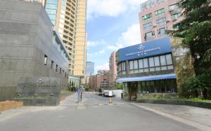 a person riding a bike down a street in a city at Green Court Residence Jinqiao Diamond Shanghai in Shanghai