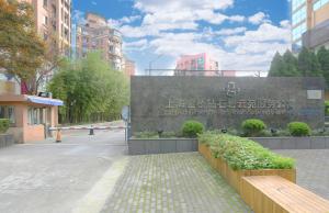 een bord in het midden van een stad met gebouwen bij Green Court Residence Jinqiao Diamond Shanghai in Shanghai