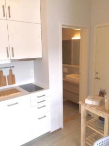 una cocina con armarios blancos y fregadero en Knudsen Apartment en Bergen