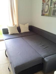 a couch with two pillows on it in a room at Knudsen Apartment in Bergen