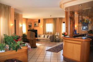 a large living room with a couch and a kitchen at Hotel Les Saisons in Saint Vincent