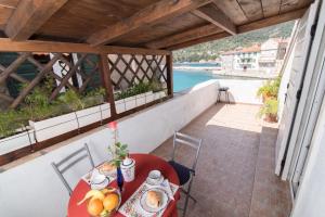 a table with a plate of food on a balcony at Apartments On the Beach in Komiža