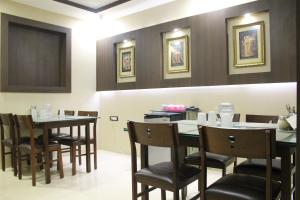 a dining room with two tables and chairs at Ekanaa Cottages in Chennai