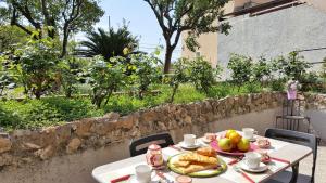 - une table avec une assiette de pain et des fruits dans l'établissement Casa Agrumeto by Holiday World, à Gênes
