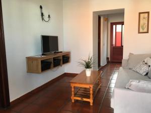 a living room with a couch and a tv on a wall at Casas La Torre in Isora
