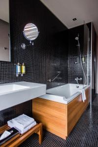 a bathroom with a white tub and a sink at Hotel Yasmin Košice in Košice