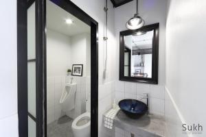 a bathroom with a toilet and a sink and a mirror at Sukh Serviced Apartment in Ban Kohong +28 photos