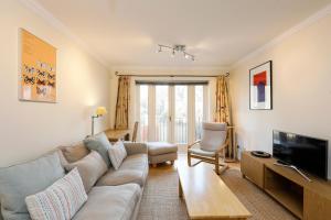 een woonkamer met een bank en een tv bij Calm 2BR apt with parking and patio, 15mins to London Eye in Londen