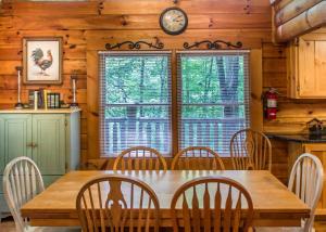 a dining room with a table and chairs and a clock at Mountain Music #19 in Sevierville