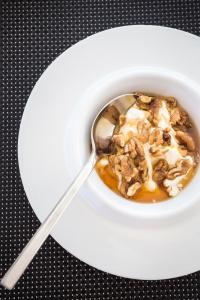 a bowl of oatmeal with a spoon on a plate at Amyth of Mykonos Super Paradise in Super Paradise Beach