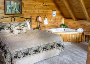 Schlafzimmer mit einem Bett und einer Badewanne in der Unterkunft Bear Hug #18 in Sevierville