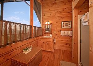 a log cabin bathroom with a sink and a window at Above It All #38 in Sevierville +11 photos
