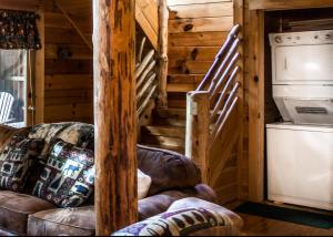 a living room with a leather couch and a staircase at Bear Hug #18 in Sevierville