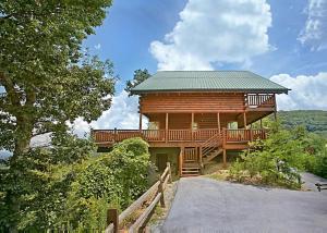 a large wooden cabin with a porch and a walkway at Above It All #38 in Sevierville