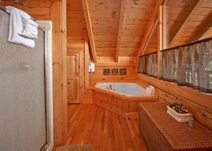 a large bathroom with a tub in a log cabin at Above It All #38 by Venture Smoky Mountains in Sevierville +91 photos