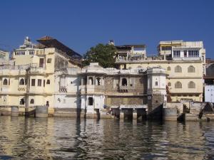 a group of buildings sitting in the water at Lalghat Haveli in Udaipur