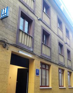 a building with a yellow door and windows at Nap Carta Puebla in Oviedo