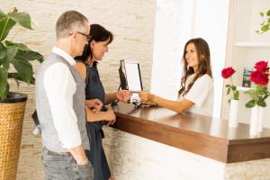 a man and two women standing at a counter with a baby at Riegersburgerhof in Riegersburg