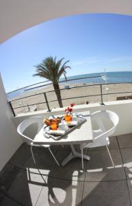 a table with a plate of food on a balcony overlooking the beach at Hôtel Restaurant Splendid Camargue in Le Grau-du-Roi