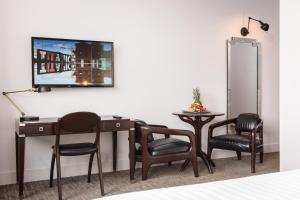 una stanza con una scrivania, sedie e una TV di Titanic Hotel Belfast a Belfast