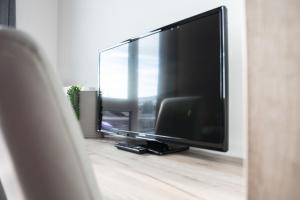 a large flat screen tv in a living room at FirstSleep Boardinghouse Griesfeldstrasse München in Munich