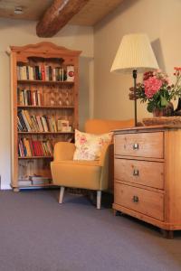 een woonkamer met een stoel, een lamp en een ladekast bij BB Baischhof Barabein in Warthausen +8 foto's