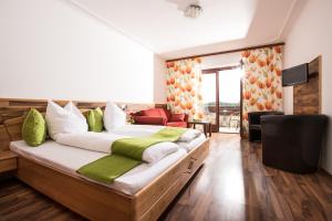 Un dormitorio con una cama grande con almohadas verdes y blancas en Riegersburgerhof, en Riegersburg