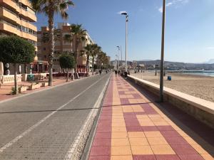 una calle vacía con palmeras y una playa en Apartments Campello, en El Campello