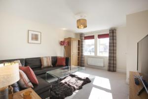 a living room with a couch and a glass table at DBS Serviced Apartments - The Stretton in Castle Donington