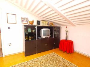 - un salon avec une télévision et une table rouge dans l'établissement Apartments in Medulin 713, à Medulin