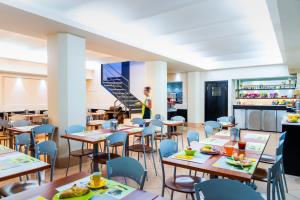 restauracja ze stołami i krzesłami oraz schodami w obiekcie Ibis Styles Milano Centro w Mediolanie
