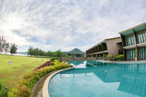 a resort with a swimming pool next to a building at La Isla Pranburi Beach Resort in Sam Roi Yot