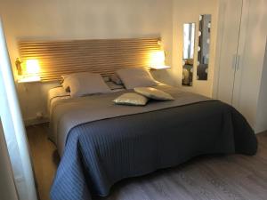 a bedroom with a large bed with two pillows on it at Fenêtres sur Mer Arromanches in Arromanches-les-Bains