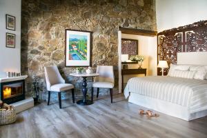 a bedroom with a bed and a stone wall at Casale Panayiotis in Kalopanayiotis +37 photos