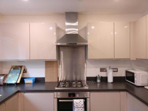 a kitchen with white cabinets and a stove top oven at Arena House in Manchester