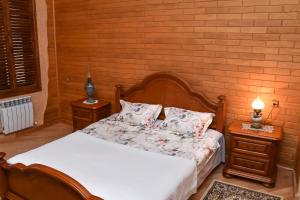 a bedroom with a bed with two night stands and a lamp at Sofia in Kutaisi