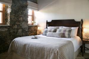 a bedroom with a large bed with a stone wall at Casale Panayiotis in Kalopanayiotis