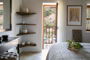 a bedroom with a bed and a door to a balcony at Casale Panayiotis in Kalopanayiotis
