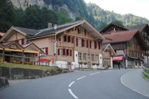 ein Gebäude an der Seite einer Straße in einem Berg in der Unterkunft Chalet Rosa B&B in Lauterbrunnen