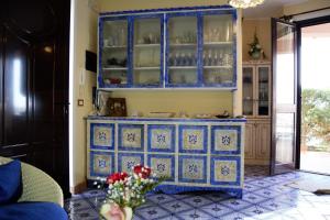アックエドルチにあるL’altra Sicilia…da Amareのキッチン(食器が入った青いキャビネット付)