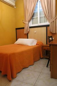 1 dormitorio con 2 camas y ventana en Hostal Don Juan I, en Alcalá de Henares