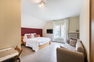 a hotel room with a bed and a couch at B&B Vis-à-Vis in Wenduine