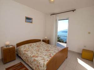 a bedroom with a bed and a view of the ocean at Apartments Rabac 981 in Rabac