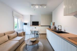 kuchnia i salon z kanapą i stołem w obiekcie B&B visavis w mieście Wenduine