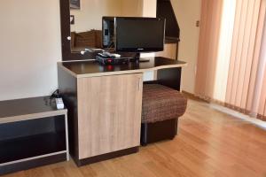 a desk with a computer and a monitor and a chair at Family Hotel Saint George in Sinemorets