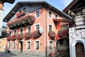 a pink building with flower boxes on it at Gasthof Zum Stollhofer in Inzing