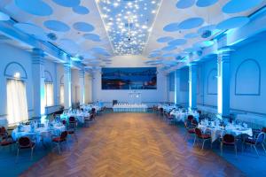 a banquet hall with white tables and chairs at ConventGarten in Rendsburg