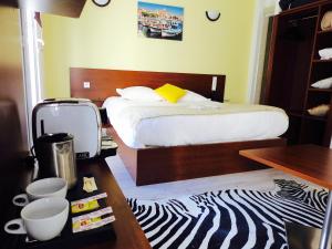 a small room with a bed, coffee table and a microwave at Massilia hôtel in Marseille