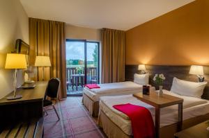Pokój hotelowy z 2 łóżkami i biurkiem w obiekcie Mikołajki Resort Hotel & Spa Jora Wielka w mieście Mikołajki