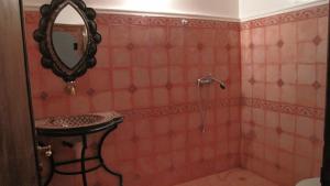 a bathroom with a sink and a shower with a mirror at Kasbah Ait Bouguemez in Agouti